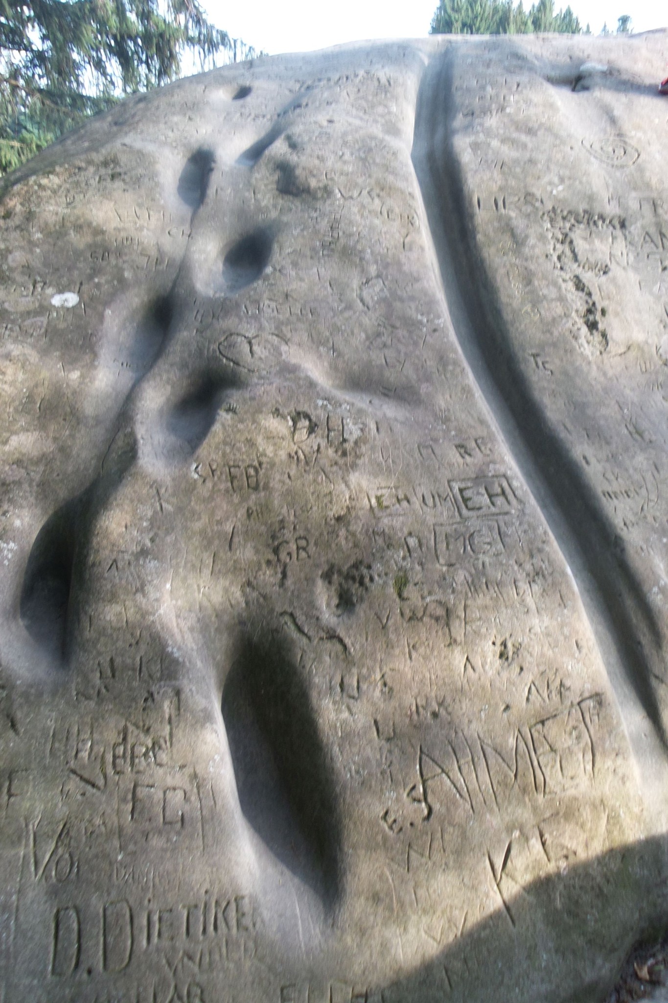 Tritte und Rinnen und viele Zeichen und Buchstaben sind in den Stein gehauen