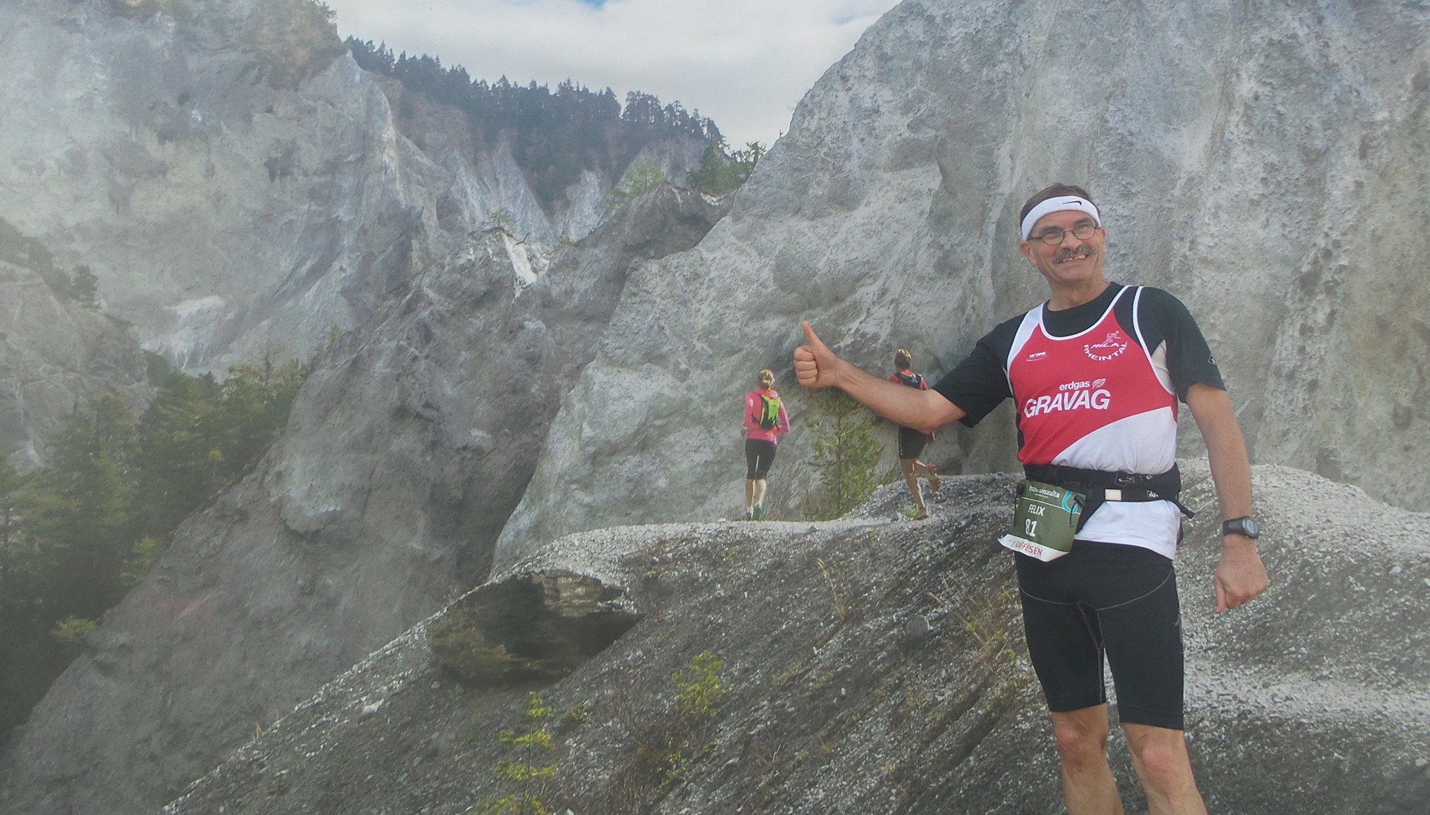 Felix posiert zufrieden im Ziel vor dem Werbefoto vom Transruinaulta